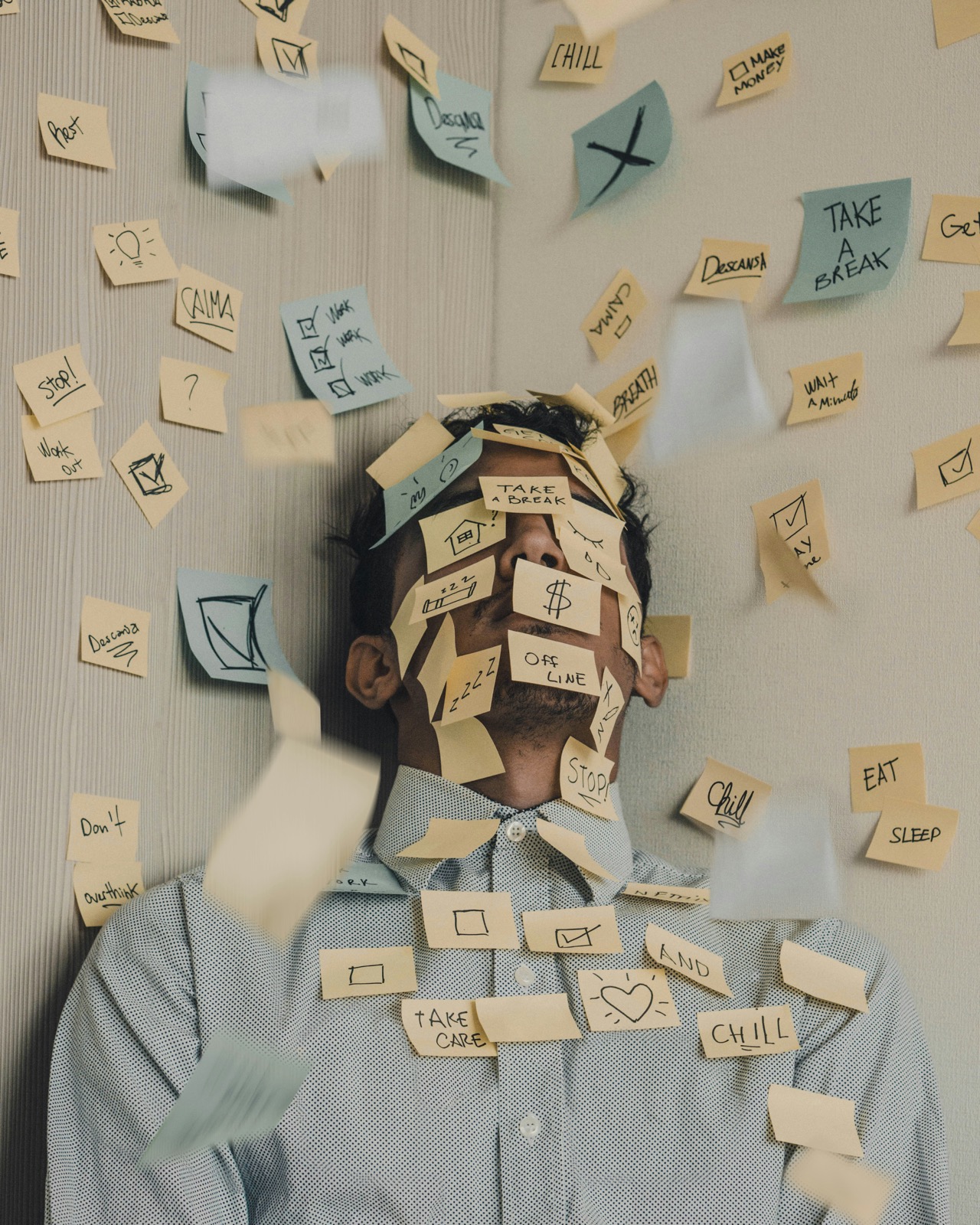 Person with sticky notes covering their face, overwhelmed by tasks